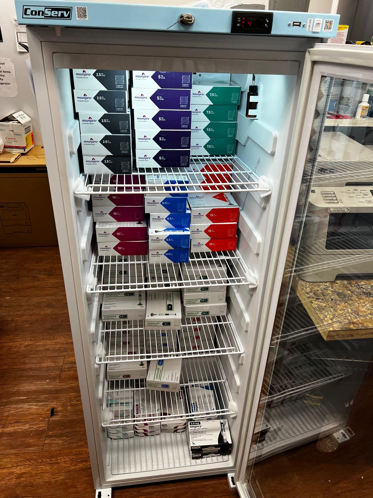 Pharmacy refrigerator stocked with Mounjaro, Zepbound, and Wegovy GLP-1 medications